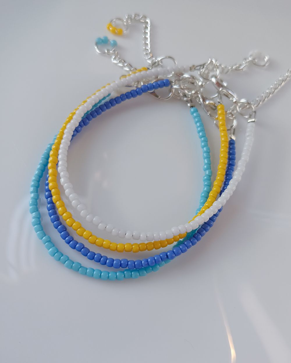 Minimal beaded bracelet stack that is handcrafted with high quality Japanese seed beads. The stack consists of 4 individual bracelets - yellow, white, sky blue and periwinkle blue. Perfect to style with any outfit.