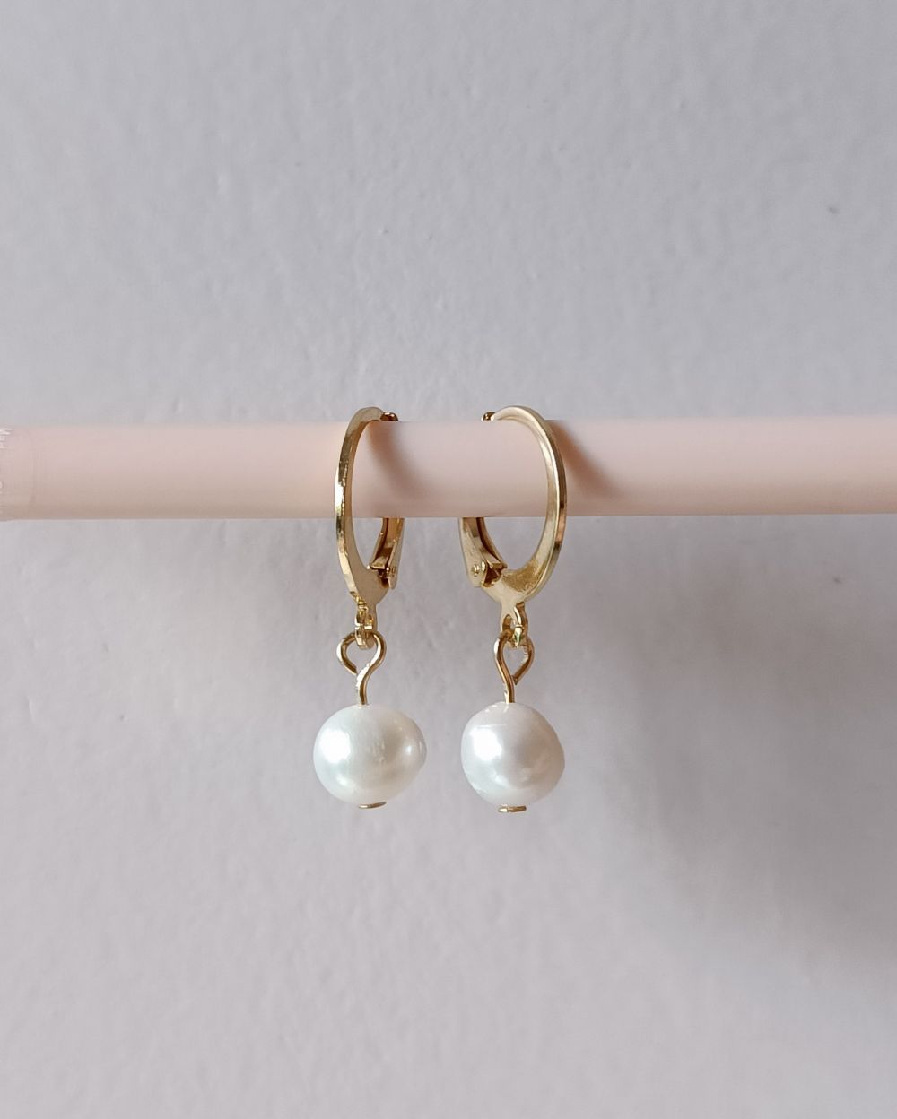Stainless steel pearl hoop earrings that is handmade with 18k gold plated stainless steel and freshwater pearls