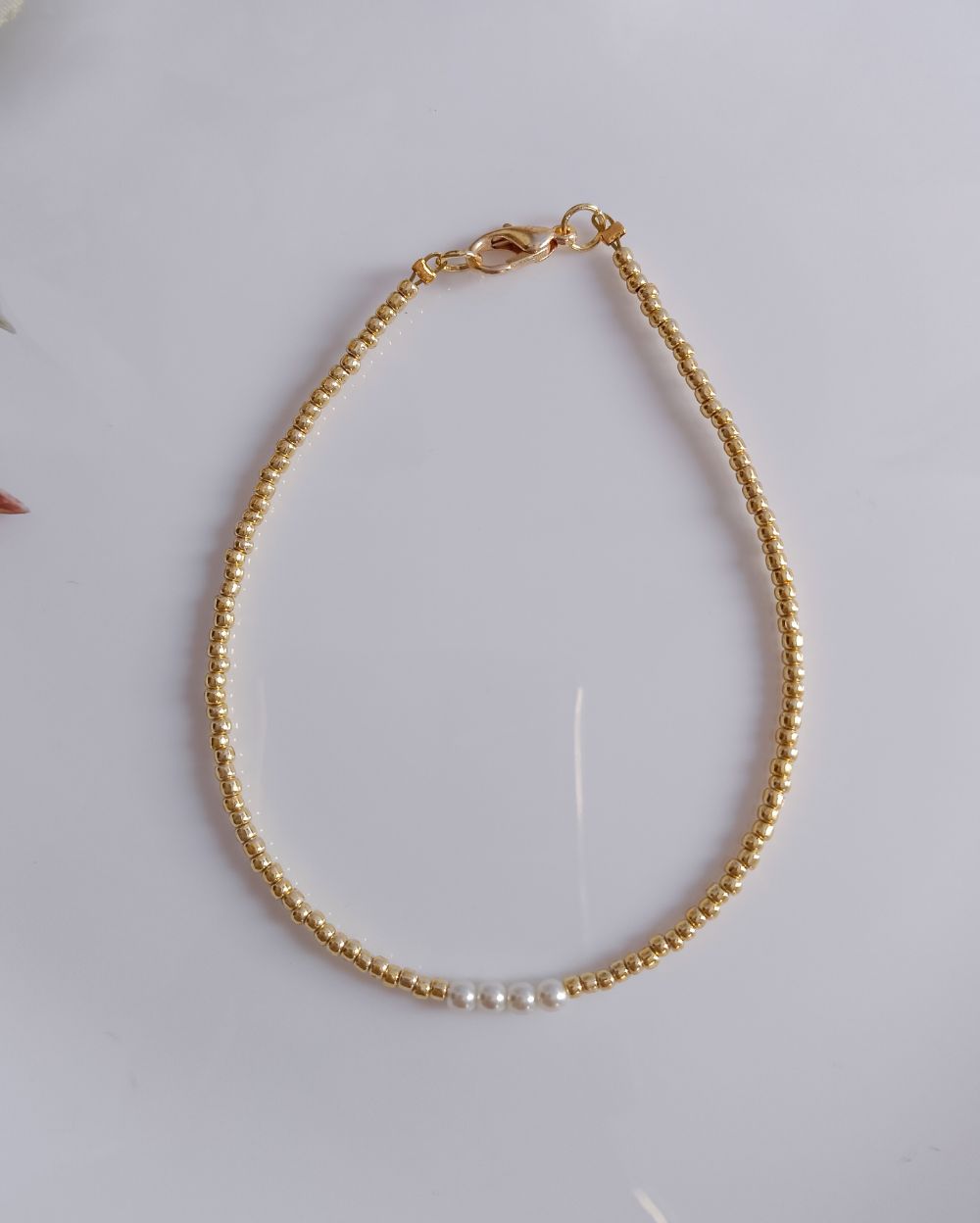 This anklet is handmade with high quality Japanese seed beads in golden shade and it has pearls in the center. This anklet comes in different sizes and can be customized to your size