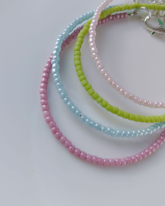 Minimal beaded bracelet stack that is handcrafted with high quality Japanese seed beads and consists of 4 individual bracelet - baby pink, pastel green, pale blue and pale mauve. Pastel bracelet stack to style with any outfit.