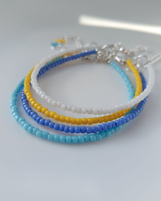 Minimal Bracelet stack that s handcrafted with high quality Japanese seed beads in 4 different colors - white, yellow, sky blue and periwinkle blue. It's super chic and can be styled in many ways - wear it as a stack or stack the single bracelet with other bracelets.